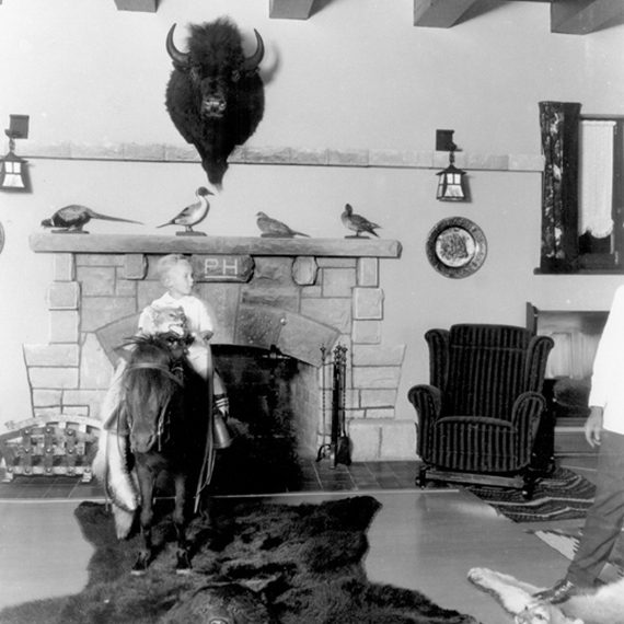Waite Phillips’ son, Elliot Waite “Chope” Phillips, photographed sitting atop his favorite pony in the Mansion’s living room, circa 1920-1926.