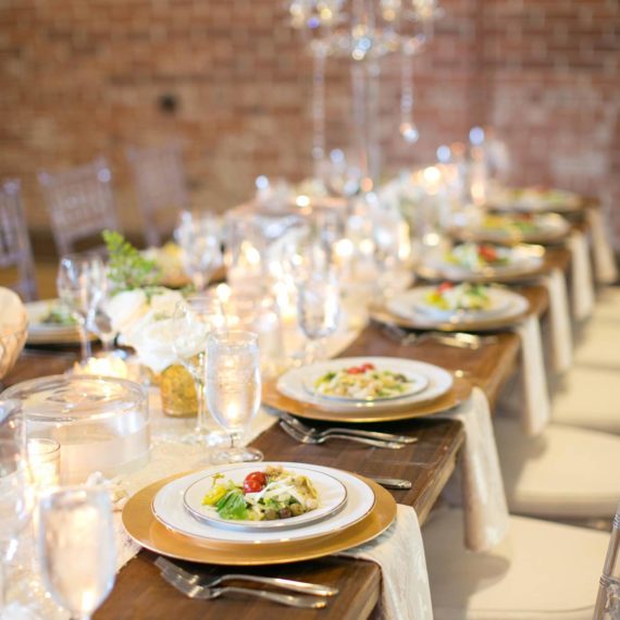 Elegant place settings on a long wooden table