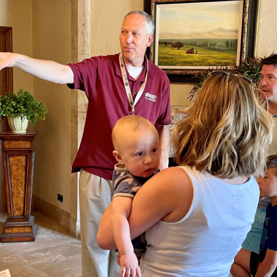 A tour guide points out directions to a family of four during Mother's Day Open Hours.