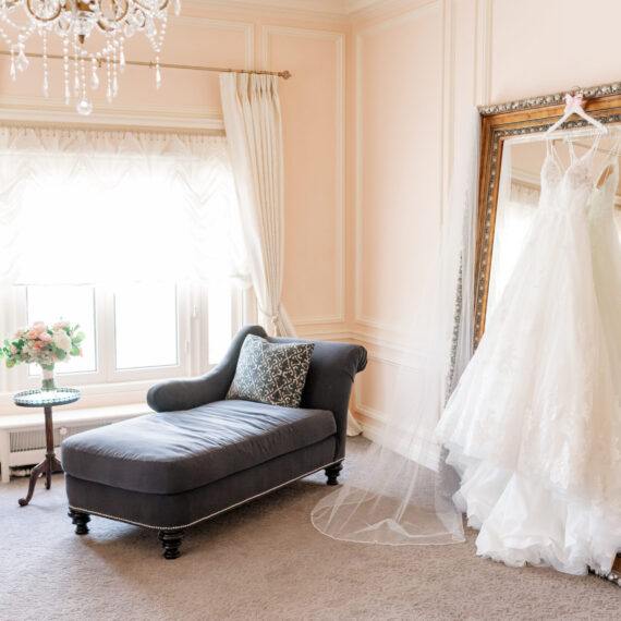 The Bridal Suite of the Highlands Ranch Mansion with a wedding dress hanging in front of the floor mirror.