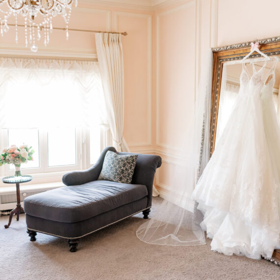 A dress hangs in front of the Bridal Suite mirror.