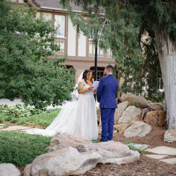 A bride and groom exchange vows on the back lawn of the Mansion.