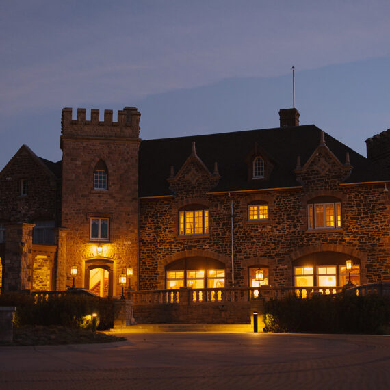 The Highlands Ranch Mansion lit up at night with warm lighting.
