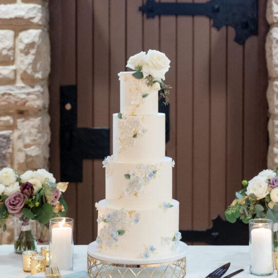 A four-tier cake sits in front of the grand door in the Great Hall.