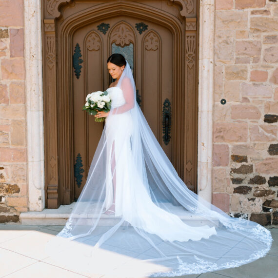 A bride poses for a portrait in front of the big front door of the Mansion.