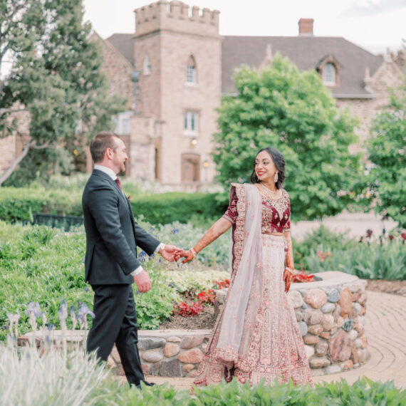 Bride and groom walk hand-in-hand in Marian's Garden.