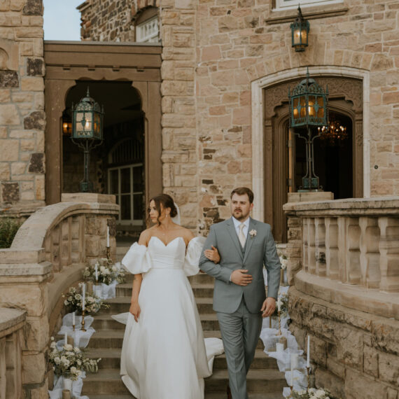 Bride and groom walk down the steps of the Mansion's front porch.