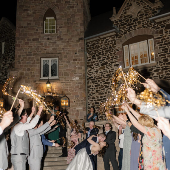 Wedding guests cheer with streamer wands as the bride and groom make their grand exit.