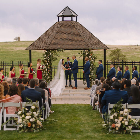 Guests watch bride and groom exchange vows at their Gazebo ceremony.