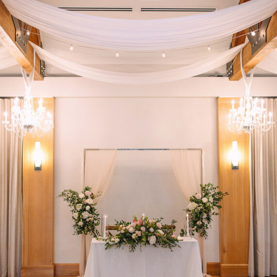 A sweetheart table in the Great Hall all dressed up with linens and florals.