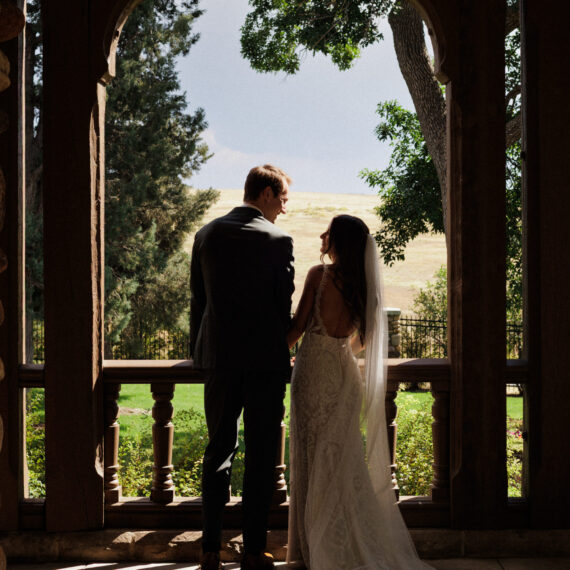 Bride and groom overlook the veranda to the Mansion's back lawn.